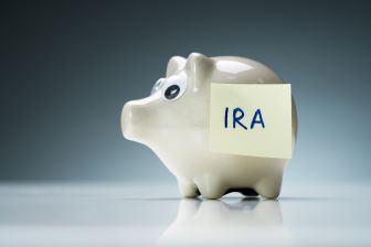 Piggy Bank with a sticky note on it with the word IRA on it